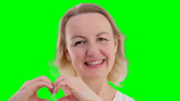 Жінка Щиро Посміхається Руками Показує Серце Прикріплюючи Очі Білому Тлі — стокове відео