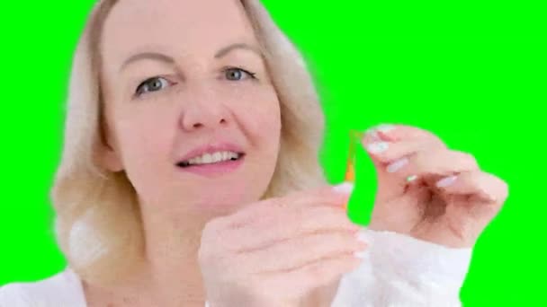 女性は新しいオレンジ歯ブラシを実証彼女は歯をきれいにするための特別なデバイスのキャップを削除し 適切に食品をきれいに歯を磨く方法を示しています — ストック動画