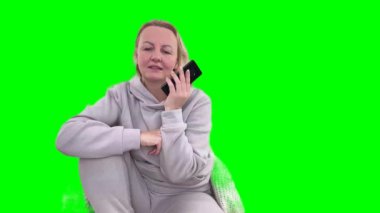 Gülümseyen orta yaşlı iş kadını akıllı telefondan gülümsüyor. Müşteriyle keyifli sohbetler ediyor. Kadın satış müdürü kârlı bir anlaşma yapıyor. 