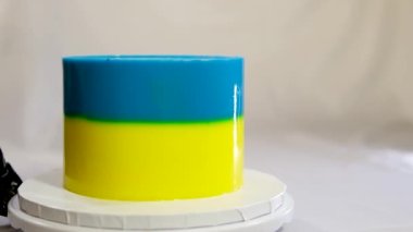 Beyaz arka planda Ukrayna bayrağı, buğday ve darı olan lezzetli bir pasta tatlısı hazırlamak ve süslemek.