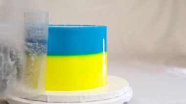 Beyaz arka planda Ukrayna bayrağı, buğday ve darı olan lezzetli bir pasta tatlısı hazırlamak ve süslemek.