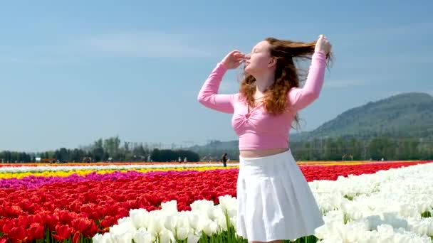 Κορίτσι Λευκή Φούστα Περπατά Μέσα Από Ένα Πεδίο Τουλίπες Χορό — Αρχείο Βίντεο