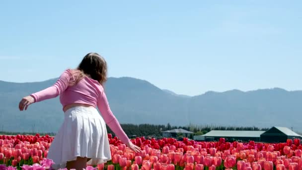 Gadis Rok Putih Berjalan Melalui Tulip Lapangan Menari Berputar Berlari — Stok Video