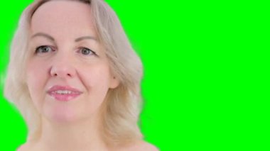 Stüdyoda duygusal kadın portresi. Neşeli kadın mavi arka planda kamerayla flört ediyor. Yavaş çekimde yüzlere dokunan neşeli bir kızın portresi. Seksi model kadın portresi