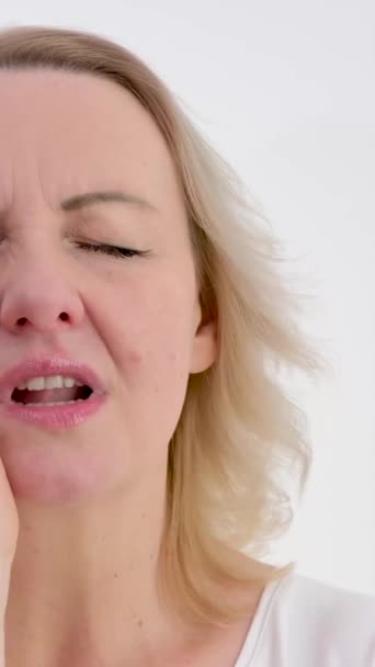 牙痛得无法忍受的女人闭上了眼睛 把手放在左脸颊处发短信叫医生不要延迟牙科治疗 — 图库视频影像
