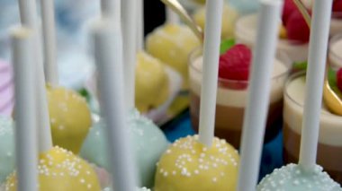 Açık büfede porsiyonlu tatlı, altın kaşıklar, peynirli jöle kuşları sütü, ahududu elmalı sütler, çikolata rengi mavi masa örtüsüyle lezzetli tatlar.