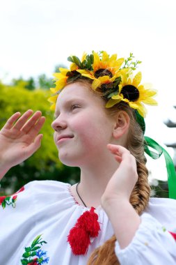 Genç, kızıl saçlı bir kız, açık havada, park bahçesinde güzel işlenmiş Ukrayna vyshyvanka gömleğiyle Ukrayna 'nın barış ve neşe dolu barış dolu barış ve neşe dolu barış dolu barış dolu zamanlarında.
