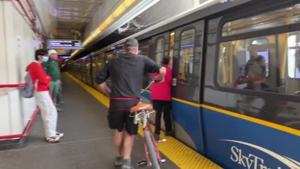 エスカレーターで地下鉄に自転車を運んでスカイトレインに乗り上げ自信のある人カナダバンクーバー2023 — ストック動画