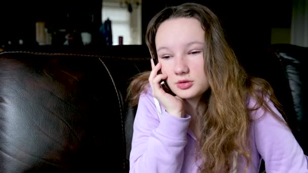 少女在黑暗的房间里用电话交谈淡紫色衬衫飘扬的头发不同的情绪青少年青春期解决与朋友交流的问题社交网络 — 图库视频影像