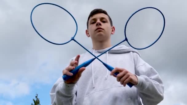 Badminton Man Gekruist Rackets Tegen Hemel Jongen Staat Tegen Achtergrond — Stockvideo