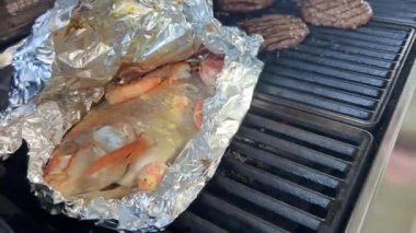  Balık kızartılmış kırmızı levrek balığının içinde beyaz ve kırmızı levrek açık bir ateşin üzerinde folyonun içine bakın evde lezzetli ve sağlıklı yiyecekler var