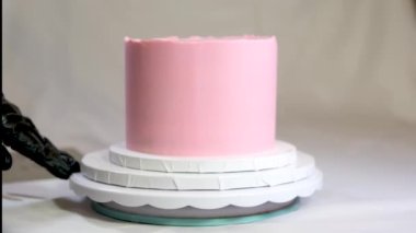 Lezzetli pembe bir pastanın dekorasyonu bir çocuğun doğumu için ve tatlının yanında vaftiz edilmiş bacak izleri için.