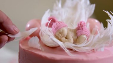 Lezzetli pembe bir pastanın dekorasyonu bir çocuğun doğumu için ve tatlının yanında vaftiz edilmiş bacak izleri için.