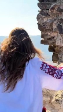 Ne yazık ki eski bir şatonun harabelerinde nakışlı bluz giyen Ukraynalı genç bir kız yok ve ne yazık ki etrafa bakıyor. Yüksek kalite 4k görüntü