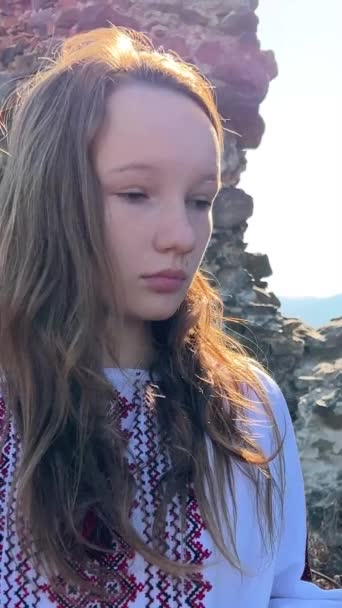 在一座古城堡的废墟上 没有一个身穿绣花女衫的乌克兰少女悲伤地看着周围的一切 高质量的4K镜头 — 图库视频影像