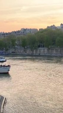 Paris, Fransa. Eyfel Kulesi 'nin manzarası ve denizde bir tekne. Beaugrenelle turist bölgesi. Metal bir köprüde üstten metro geçiyor. Seine nehrinin üzerinde gün doğumu