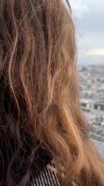 Eyfel kulesindeki bir kız Paris şehrine bakar. Seine Nehri 'nin görülebilir evleri, tekneleri ve Paris Fransa' nın merkezi. Yüksek kalite 4k görüntü