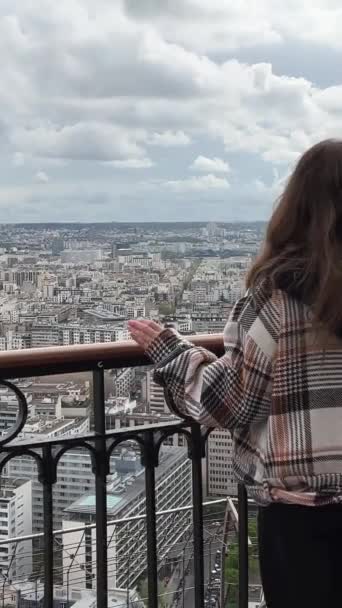 在埃菲尔铁塔上的一个女孩环顾四周 看见塞纳河上有很多船和巴黎市中心的房子 高质量的4K镜头 — 图库视频影像
