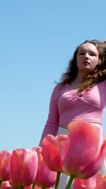 年轻的少女站在城市里 有着粉色的郁金香 遥望远方 遥望未来 无处可寻自由纯真清新的风向发展 — 图库视频影像
