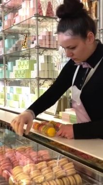 Fransa, Nice, 22.04.23 Laduree mağazasından ünlü Fransız makarnaları çizen bir yazıcı ile makarona basılmış. Yeşil, özel bir hediye kutusu ahşap arka plan. Hediyelik kutusunda çeşitli Laduree makarnaları var..