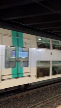 İstasyondan istasyona giden yeşil ve gri renkli bir trenin yanından geçen bir metro treni görülmüyor. Yüksek kalite 4k görüntü
