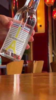 Limonata Parismonade, kahverengi ahşap bir kafe olan 03.05.23 Paris Fransa 'da buzlu ve limonlu bir bardağa doldurulur. Yüksek kalite 4k görüntü