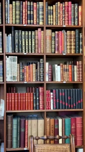 天井にちょうどラックの上に厚いシックな結合スタンドで図書館ストア内の棚に収集可能な本 ヒューゴ モリエールや他の著者による本があります26 23パリフランス — ストック動画