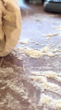 Yaşlı bir kadının yaşlı elleri hamuru yuvarlar ve bir şeyler pişirir ya da hamur köftelerini ya da hamur köftelerini ahşap bir yüzeyde kaynatır. Yüksek kalite 4k görüntü