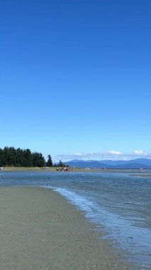 the coast of the Pacific Ocean on Vancouver Island, it can be seen that there was a low tide and now the calm of the wave is barely splashing on the amulet calm silence Rathtrevor Beach, Parksville.