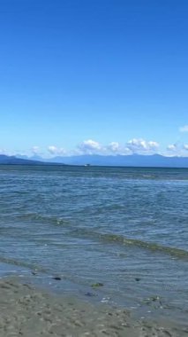the coast of the Pacific Ocean on Vancouver Island, it can be seen that there was a low tide and now the calm of the wave is barely splashing on the amulet calm silence Rathtrevor Beach, Parksville.