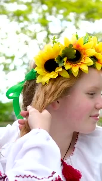 赤い髪を持つ編組の女の子の花輪でひまわり明るいですガールフレンド美しいです若い女性編組お互いの髪お祝いのための準備のためのドレッシングを飾るウクライナの休日 — ストック動画