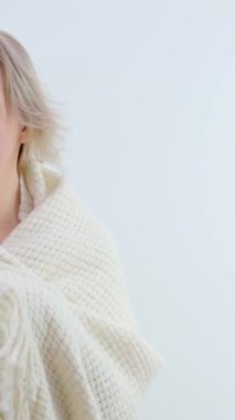 Sevimli, orta yaşlı bir kadın omuzlarının üzerine sıcak yün ekose atıyor. Metin kadın saçlarını düzleştiriyor. Elektrikli ısıtıcıları soğuk tutuyor. 