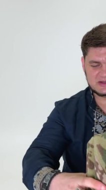 Ukrayna uyruklu bir adam paltosunu çıkarıp koluna asıyor mavi vyshyvanka