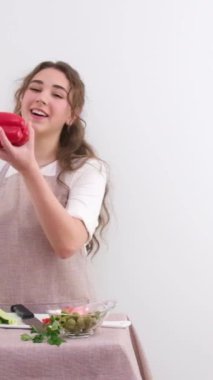 Ağır çekim HD 240 fps genç kız kırmızı dolma biber atıyor mesaj pişirme programının yemek pişirme bölümü için içtenlikle uzay mekanına gülüyor videonun sonu 