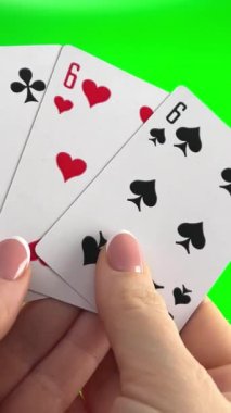 Yeşil arka planda dört tane altı el ele tutuşmuş. Fransız manikürlü kadın elleri. Kadın kartları ayırıyor, inceliyor, birleştiriyor ve bir fan gibi dağıtıyor.