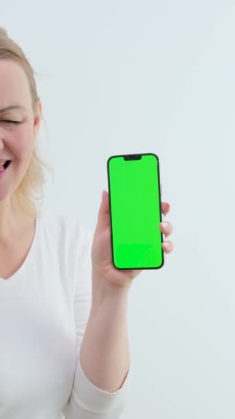 緑の画面を持つ大人の女性携帯電話Chromakeyスペースのためにテキスト笑いダンス喜びショー手のポップのアブラカドラ親指アップOk携帯電話に見える — ストック動画
