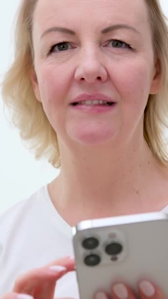 Zbliżenie Kobieta Przewracając Strony Biały Telefon Delikatny Uśmiech Średni Wiek — Wideo stockowe