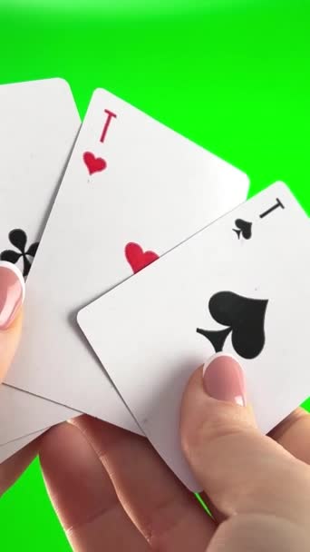 フランスのマニキュアで緑の背景クローズアップ女性の手に4つのエースを保持手 女性はカードを並べ替え折り目を調べ同じスートのファン4枚のカードのように広がり — ストック動画