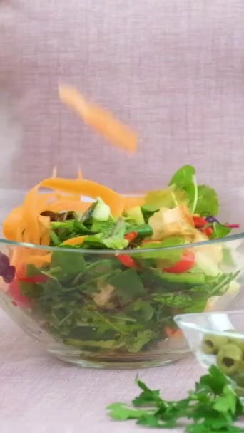 おいしい新鮮な野菜サラダ散布の女性ニンジンの多くのプレートに攪拌緑クルトンテーブルの上にパルメザンキュウリオリーブ赤ピーマントマト異なる — ストック動画