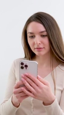 Genç bir kadın cep telefonu kullanıyor, mesaj yolluyor, mesaj yazıyor, geçmişi gri. Yüksek kalite 4k görüntü