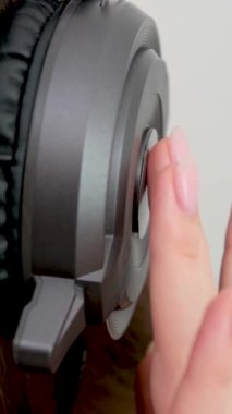 Yakın plan parmaklar, müzik dinleyen büyük profesyonel kulaklığa vuruyor. Metin müzikali için parmaklarını yere vuruyor. Müzik dersi veriyor. 