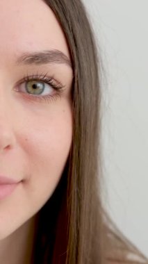 Genç bir kadının yakın plan portresi pozitif anlamda rastgele bir portredir, büyük bir gülümseme, stüdyoda beyaz arka planda poz veren güzel bir manken. Beyaz kadın portresi..