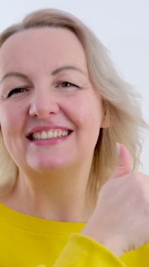 Kawaii gündelik kadın sarı tulum giyer, baş parmağını kaldırır, olumlu el hareketi, iyi iş, saygı gösterir. En az biçimlendirilmiş