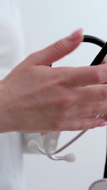 Стетоскоп Белом Фоне Вид Сверху Руки Женщины Врача Складывающего Фонендоскоп — стоковое видео