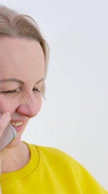 Milenyum Asyalı genç bir kadın cep telefonuna bakıyor. İyi haberlerle gülüyor ya da internetten alışveriş yapıyor. Cep telefonu uygulamasına bakan mutlu ve neşeli bir kadın heyecanlı hissediyor.