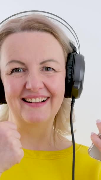 Kulaklıklı Güzel Bir Kadın Rüzgarda Çırpınarak Müzik Dinliyor Beyaz Arka — Stok video