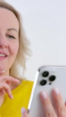 İyi haber, mutlu kadın dans eden, beyaz arka planda izole edilmiş bir telefon, neşeli bir gülümseme, heyecanlı bir kadının internetten para kazanması. Yüksek kalite 4k görüntü