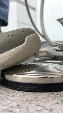 Bir diş kliniğindeki koltuğun altındaki düğmeye basan ve diş macunlarını çıkarmak ya da dişlerini doldurmak için düğmeye basan bir adamın ayağında gri bir terlik ve Ukrayna Vinnitsa diş hekimliği alanı 2023