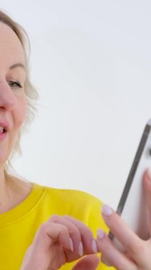 Sarışın Ukraynalı kadın gülümseyen cep telefonu kullanıyor. Genç sarışın kadın modern beyaz telefon cihazıyla çevrimiçi iletişim kuruyor. Ulak uygulaması üzerinden mesaj atan neşeli insan. Yüksek kalite 