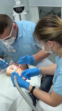 Erkek dişçi randevusunda diş hekimine gider, doktor dişlerini ağız, diş aynası, ofis, klinik, doktor, maske, sağlık, tedavi, önleme Ukrayna Vinnitsa Diş Hekimliği 12.2022 'de incelemeye başlar.